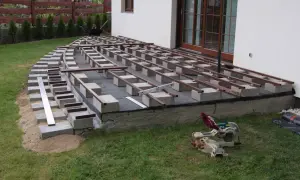 Budowa tarasu kompozytowego: widać betonowe bloczki i legary, co ile legary pod taras kompozytowy.