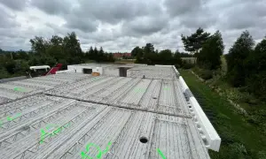 Gotowy do zalania strop filigran, z zielonymi oznaczeniami i widocznym szalunkiem traconym.