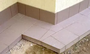 Wykonana opaska wokół domu z płytek ceramicznych, chroniąca fundament przed wilgocią.