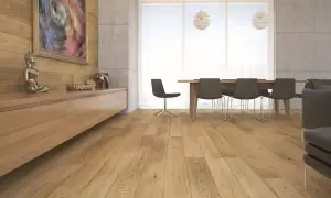 Drewniana podłoga w salonie, panele ułożone wzdłuż pomieszczenia, tworzą ciepłą atmosferę.