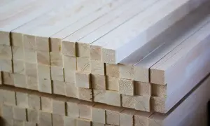 Stos drewna, idealnie przycięty krawędziak, czeka na dalszą obróbkę.