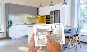 Ręce trzymają tablet z wizualizacją kuchni stworzoną w programie do projektowania kuchni.