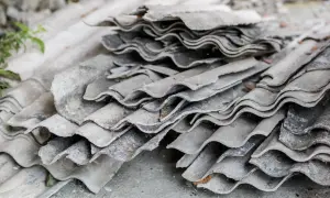 Stare, pofalowane płyty eternitowe na dachu, czekające na utylizację.