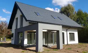 Nowoczesny dom 120 m² z szarym dachem i dużymi oknami. Zastanawiasz się, jaki koszt budowy domu 120 m²?