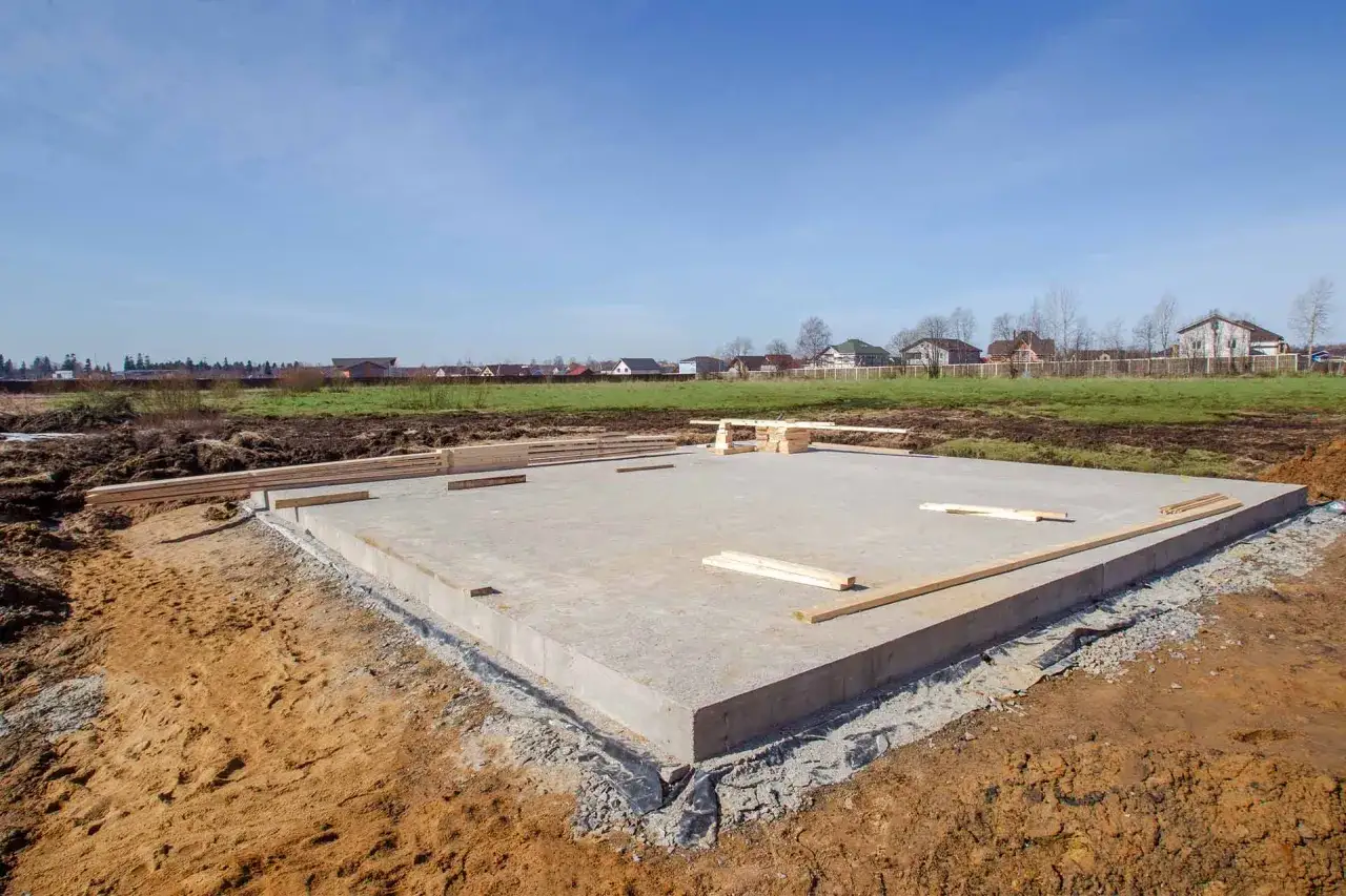 Płyta fundamentowa koszt budowy domu. Betonowa płyta fundamentowa na placu budowy, przygotowana pod dom.