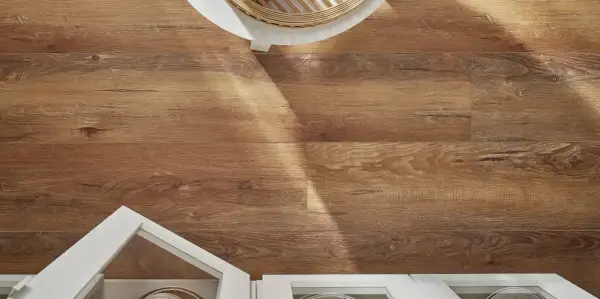 Drewnopodobne panele laminowane czy winylowe na podłodze, z widocznym fragmentem białej szafki i blatu.